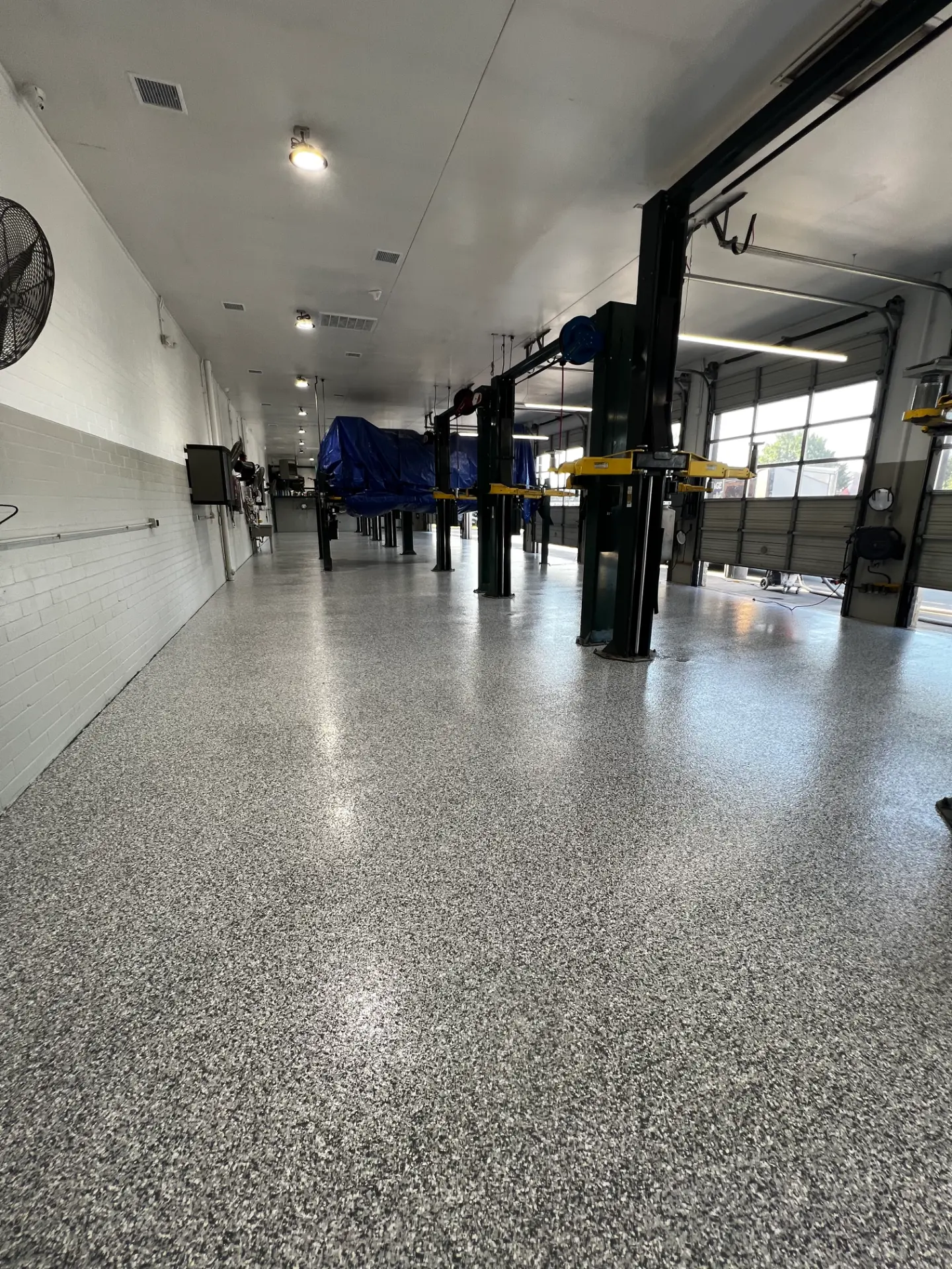 Freshly coated flake floor inside an auto repair garage bay
