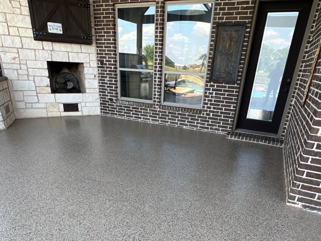 Pecan flake-coated patio floor with a high-gloss topcoat in front of a limestone fireplace
